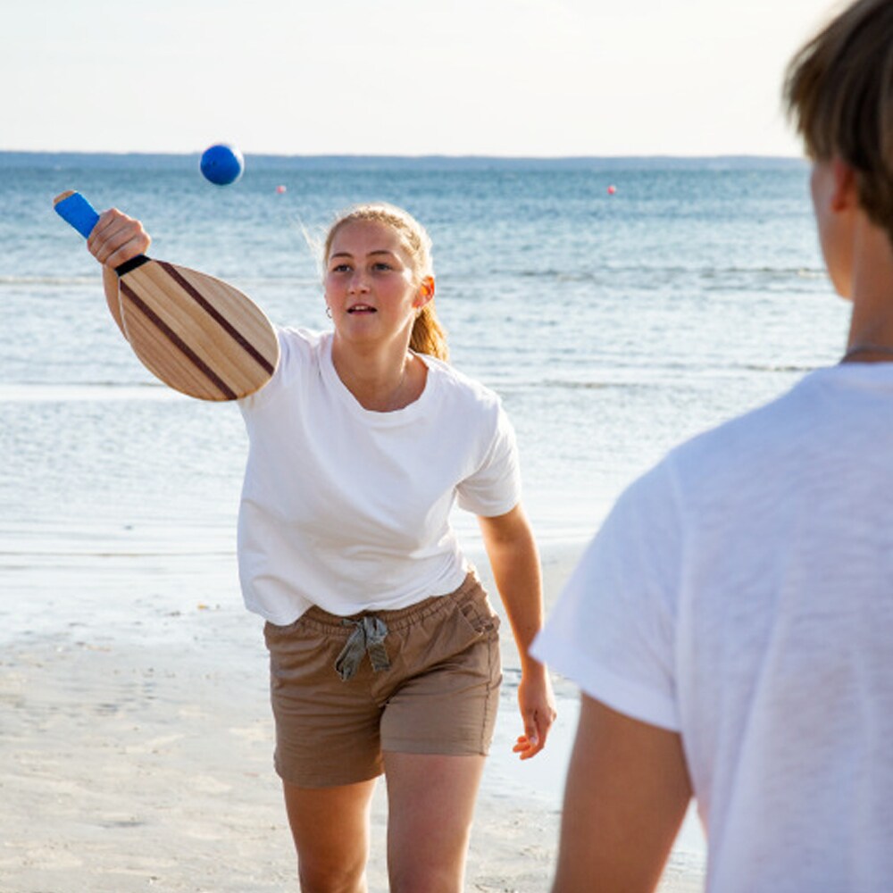 Två personer spelar strandtennis med Beach Racket Set på stranden