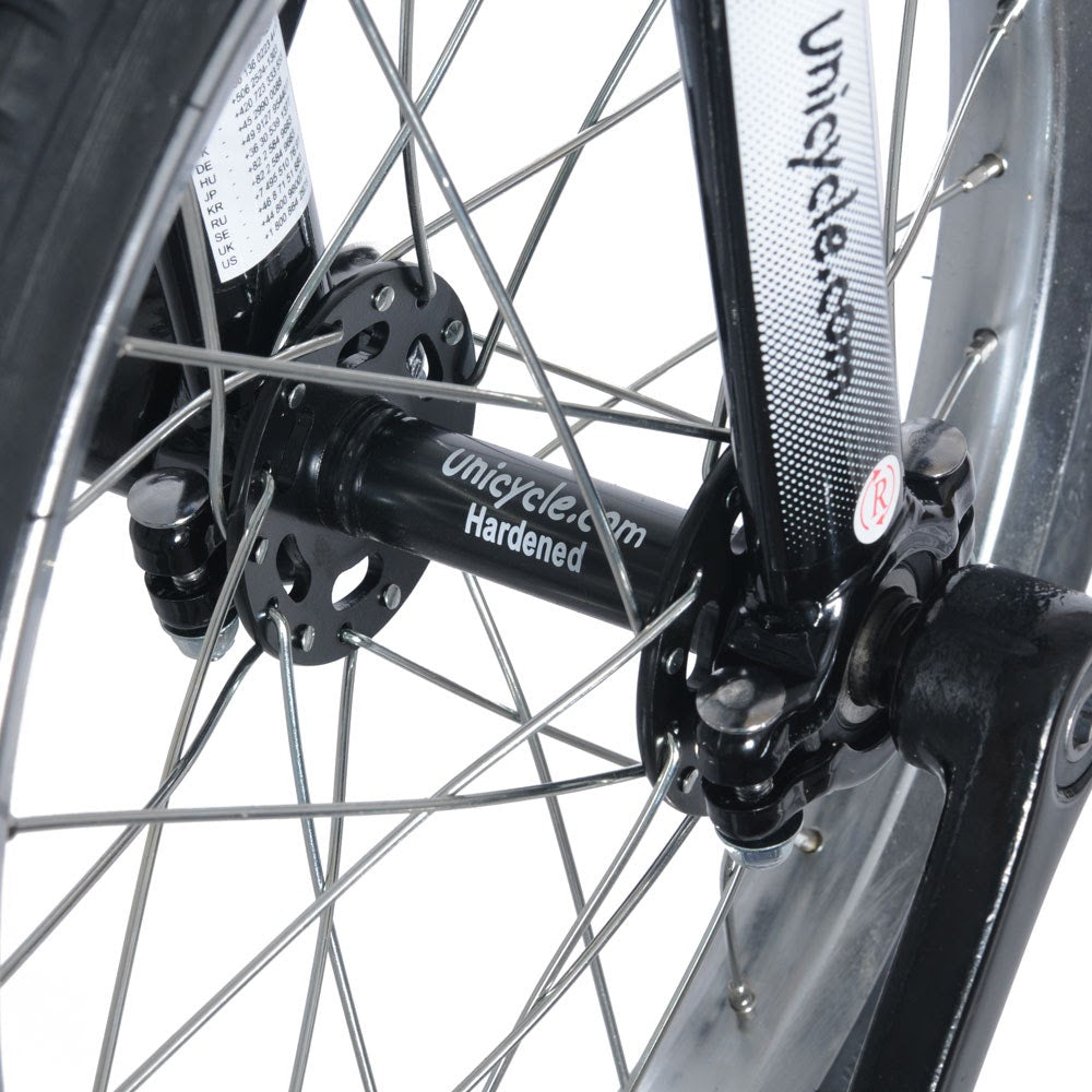 Närbild på svart nav märkt "Unicycle.com Hardened" och svart gaffel på en enhjuling. Visar nav, ekrar och vevarmens fäste