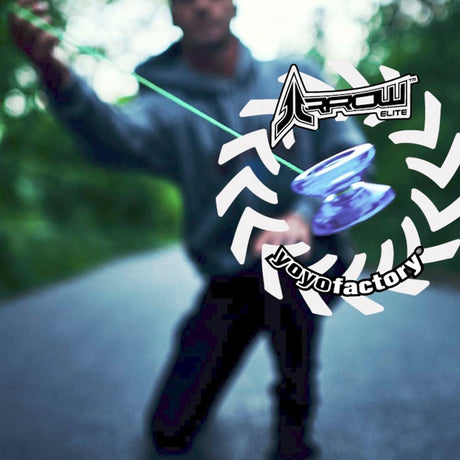 Actionbild där en lila och blå Arrow Galaxy jojo är i fokus och snurrar på ett neongrönt snöre. I bakgrunden syns konturerna av en person i en hoodie på en väg omgiven av grönska. Bilden har vit grafik med logotyperna för "Arrow Elite" och "YoyoFactory"
