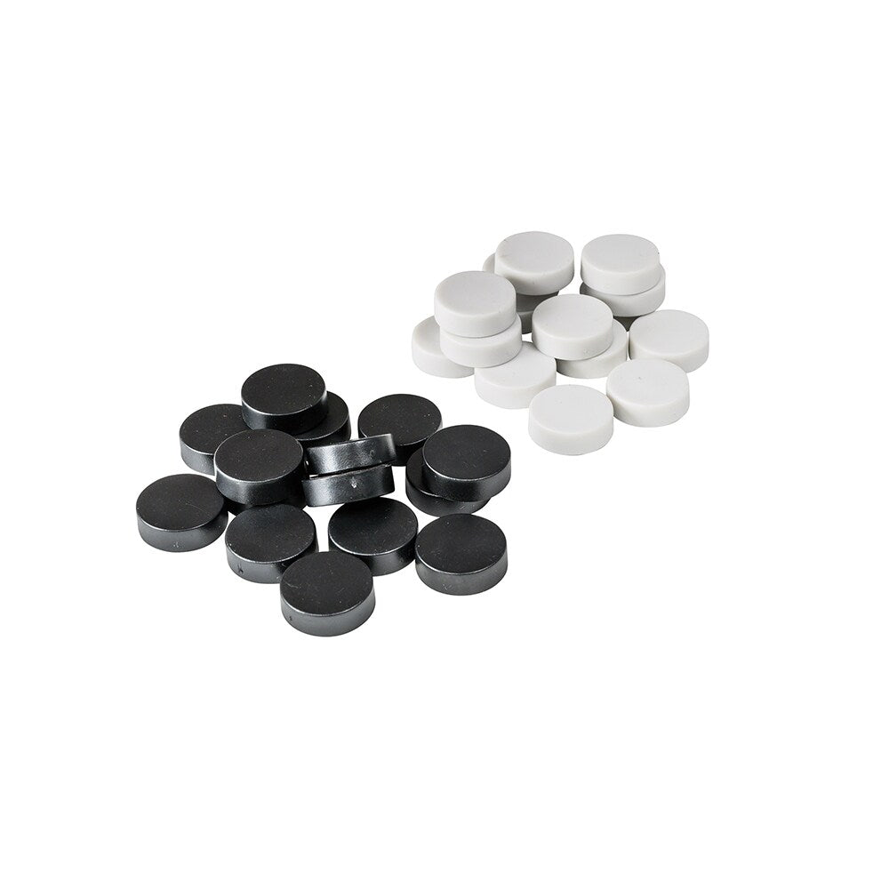 Närbild på en beige spelpjäs i plast, visar den platta magnetiska undersidan