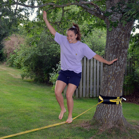 Tjej balanserar på en slackline från Gibbon – fokus, styrka och balans i rörelse