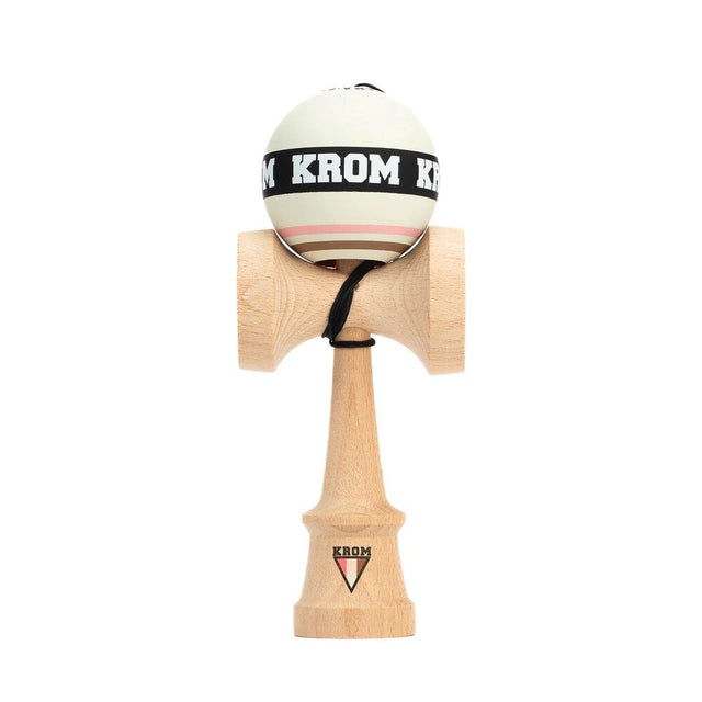 KROM Strogo Neapolitan kendama i ljust bokträ sedd framifrån med en vit boll (tama) prydd med ett svart ”KROM”-band och ränder i rosa och brunt mot en vit bakgrund.