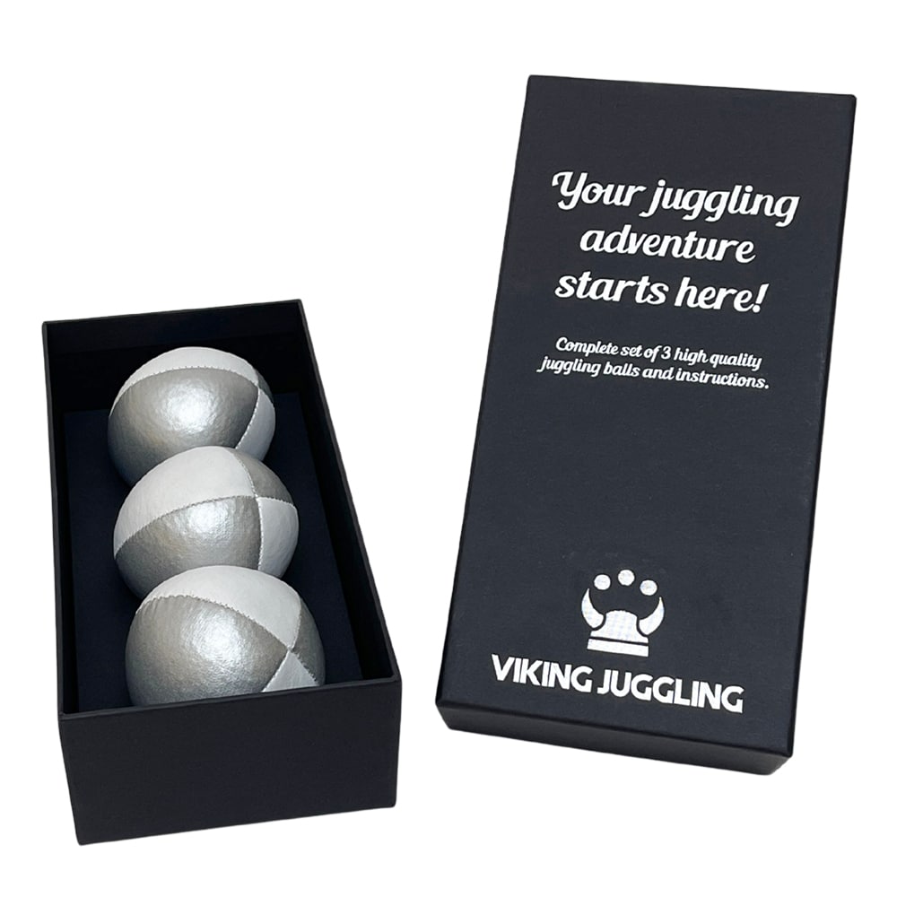 Ett set med tre silver-vita 4-panel jongleringsbollar i konstläder, presenterade i en svart presentask från Viking Juggling.
