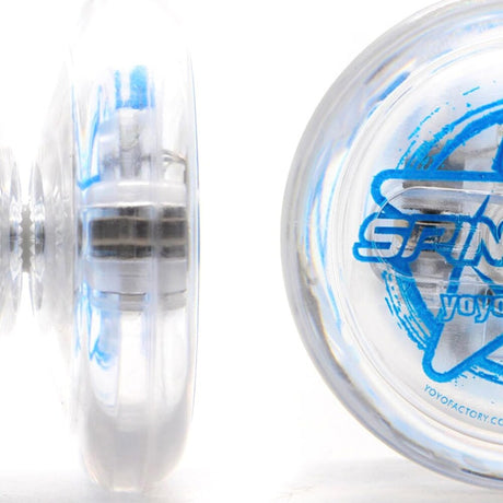 Närbild på en genomskinlig Spinstar LED jojo från YoyoFactory som visar jojons profil och kullager i genomskinlig plast. Sidan har blå grafik med texten "Spinstar" och en stjärna.