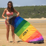Kvinna på en strand som förbereder en färgglad Symphony Beach 2.2 paragliderdrake med vitt snöre