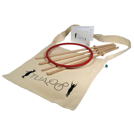 Tualoop-set bestående av en röd ring, fyra kontrollpinnar i trä och en instruktionsmanual liggande på en beige tygpåse med Tualoop-logotypen.