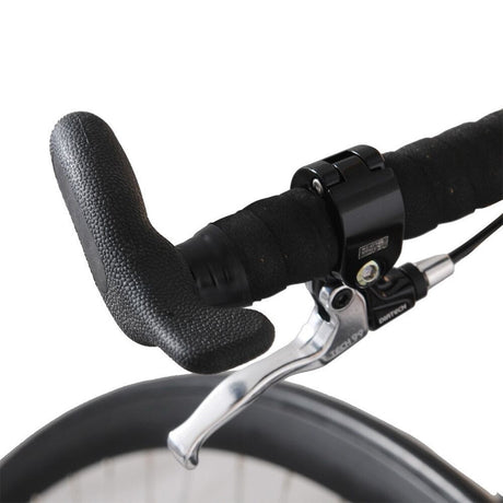 Närbild på höghjulingens styre med ergonomiskt svart grepp och Tektro-liknande silverfärgat bromshandtag