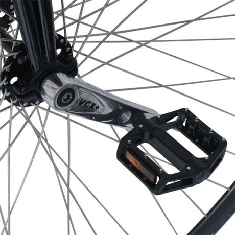 Närbild på höghjulingens nav och vevarm. Visar Nimbus VCX Plus-vevarmar i polerat stål och svarta aluminiumpedaler med dubbar