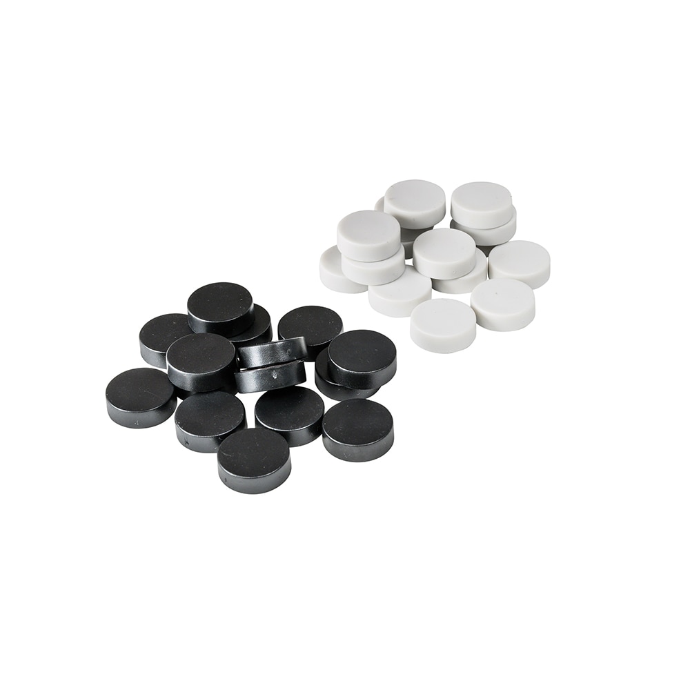 Närbild på en beige spelpjäs i plast, visar den platta magnetiska undersidan