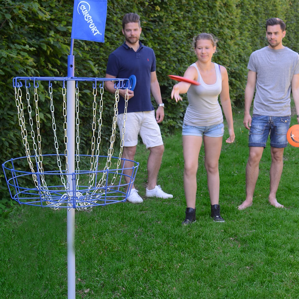 Person spelar discgolf utomhus med portabel målbur – perfekt aktivitet för trädgård eller park